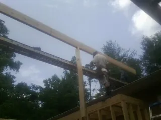 Carpenter setting a ridge beam over a new addition frame — Ice Dam Removal by Roofing Brothers in Otisville