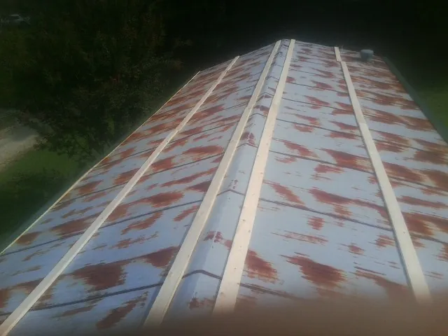 Rusted metal roof panels with new wood purlins before replacement — Storm Damage Roof Repair in Otisville by Roofing Brothers