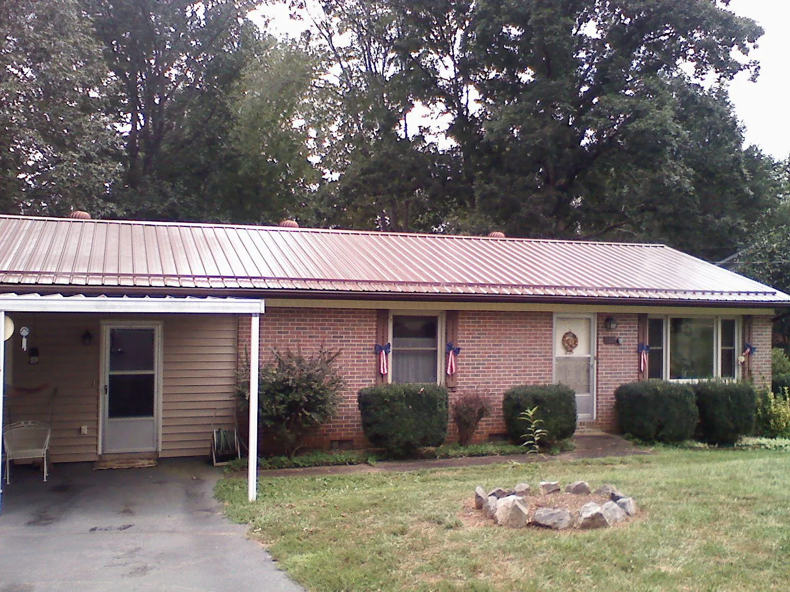 Bronze metal roof and carport on a brick ranch home — Roof Repair work by our crew in Otisville